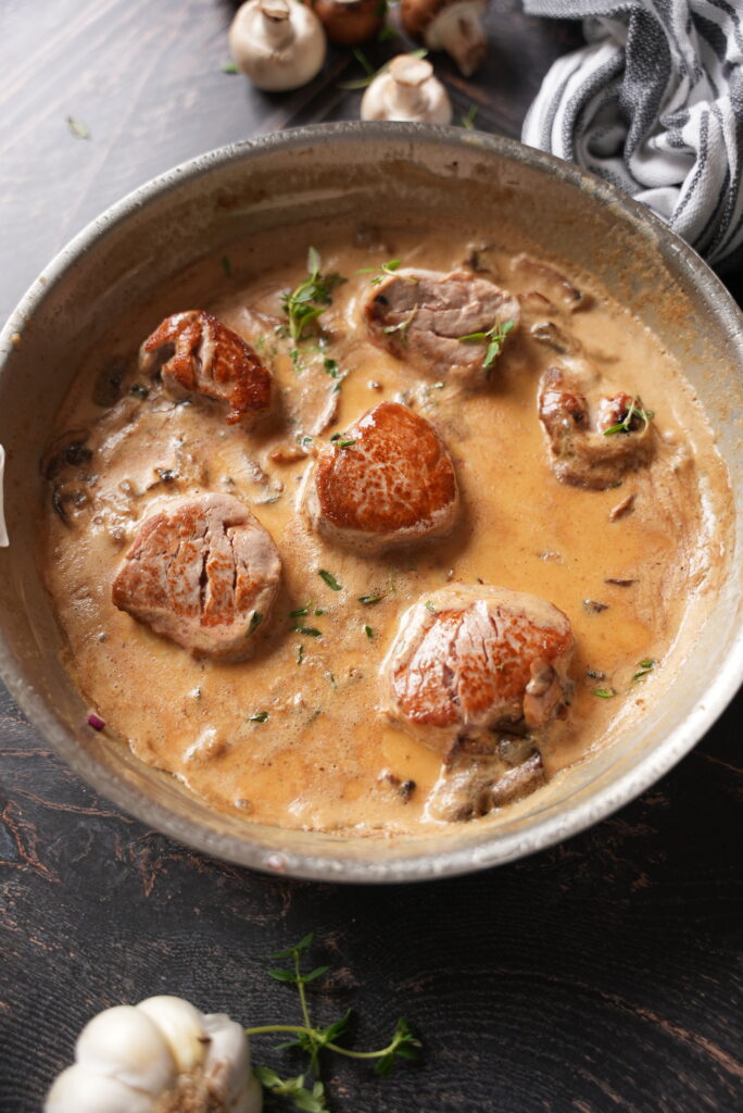 Schweinefilet in Whiskey-Sahne-Sauce ist ein Gericht, das mit seinem unvergleichlichen Geschmack und seiner raffinierten Zubereitung beeindruckt. Es ist die perfekte Wahl für ein festliches Dinner, einen besonderen Anlass oder einfach einen gemütlichen Abend mit Freunden und Familie. Die Kombination aus zartem Fleisch, einer cremigen Sauce und dem würzigen Aroma von Whiskey macht dieses Gericht zu einem echten Highlight. Doch was macht Schweinefilet in Whiskey-Sahne-Sauce so besonders, und wie gelingt die Zubereitung perfekt? In diesem Artikel erfahren Sie alles Wissenswerte. Warum Schweinefilet wählen? Schweinefilet ist eines der edelsten Stücke vom Schwein. Es ist mager, zart und äußerst vielseitig in der Zubereitung. Da es kaum Fett enthält, eignet es sich ideal für feine Gerichte, bei denen die Qualität des Fleisches im Mittelpunkt steht. In Kombination mit einer aromatischen Sauce, wie der Whiskey-Sahne-Sauce, wird das Filet zu einem echten Gaumenschmaus. Der besondere Touch: Whiskey in der Sauce Whiskey verleiht der Sauce ein unverwechselbares Aroma. Die Noten von Eiche, Karamell und manchmal sogar Vanille aus dem Whiskey ergänzen die cremige Sahne ideal. Der Alkohol verflüchtigt sich während des Kochens weitgehend, sodass nur der charakteristische Geschmack des Whiskeys zurückbleibt. Achten Sie bei der Wahl des Whiskeys darauf, eine Sorte zu wählen, die Ihnen pur schmeckt – schließlich beeinflusst sie das Aroma der gesamten Sauce. Die perfekte Begleitung Zu Schweinefilet in Whiskey-Sahne-Sauce passen Beilagen wie Bandnudeln, Kartoffelstampf oder knusprige Bratkartoffeln hervorragend. Auch gedünstetes Gemüse wie Brokkoli oder grüne Bohnen ergänzen das Gericht ideal. Für ein besonderes Highlight sorgen karamellisierte Zwiebeln oder eine frische Beilage aus grünem Salat.