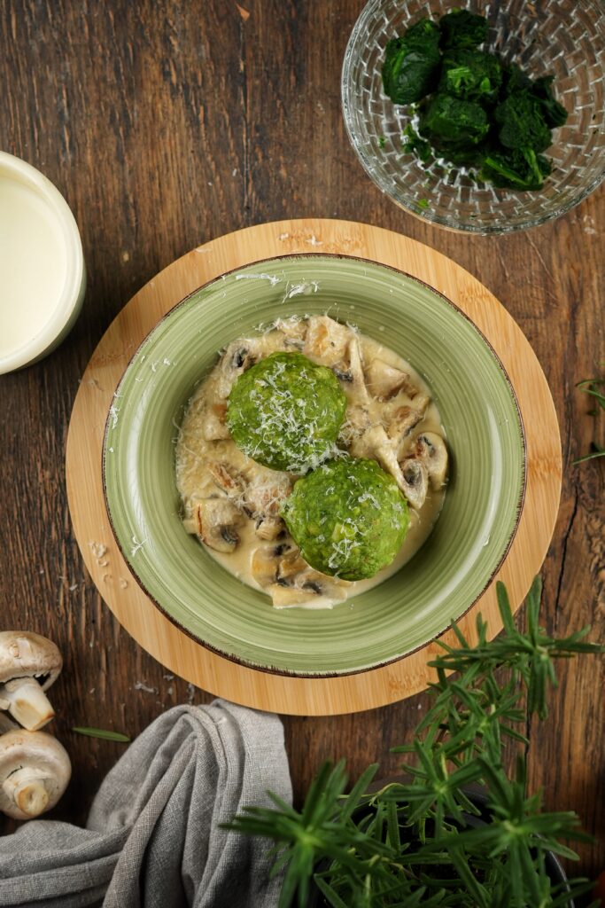 Spinatknödel mit Champignon-Rahm-Sauce: Ein Klassiker mit Geschichte und Genussmomenten