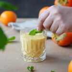Kaki-Smoothie mit Orange und Joghurt frisch serviert im Glas