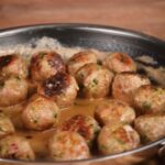 Köttbullar mit Sahnesoße und Preiselbeeren, angerichtet auf einem Teller