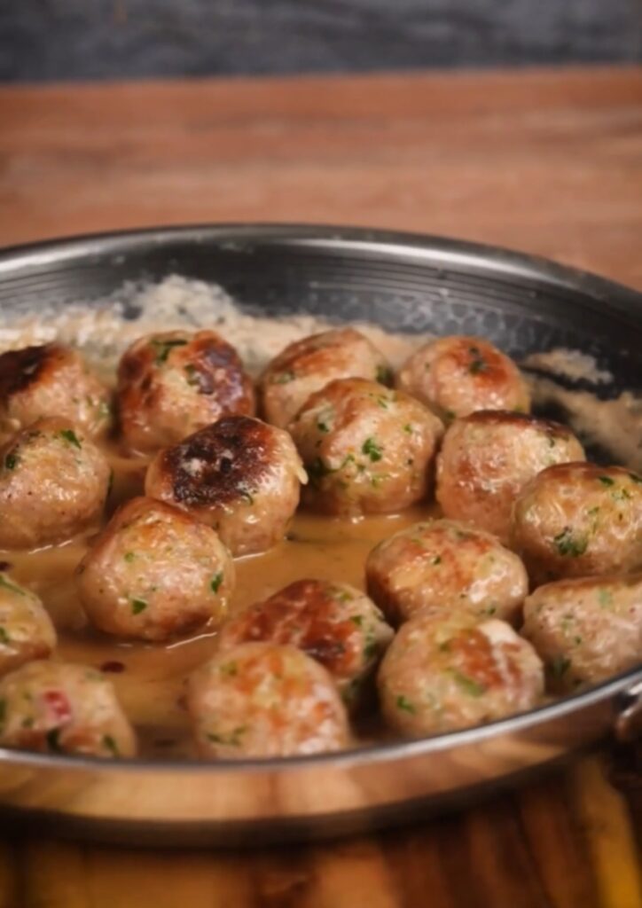 Köttbullar mit Sahnesoße und Preiselbeeren, angerichtet auf einem Teller
