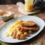 Spargel mit Sauce Hollandaise, kleinen Kartoffeln und knusprigem Schnitzel auf einem Teller