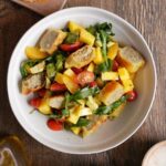 Maultaschensalat mit Mango, Orange und Avocado auf Teller angerichtet