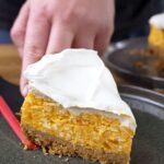 Stück Kürbis-Käsekuchen mit Schmandhaube auf einem Teller